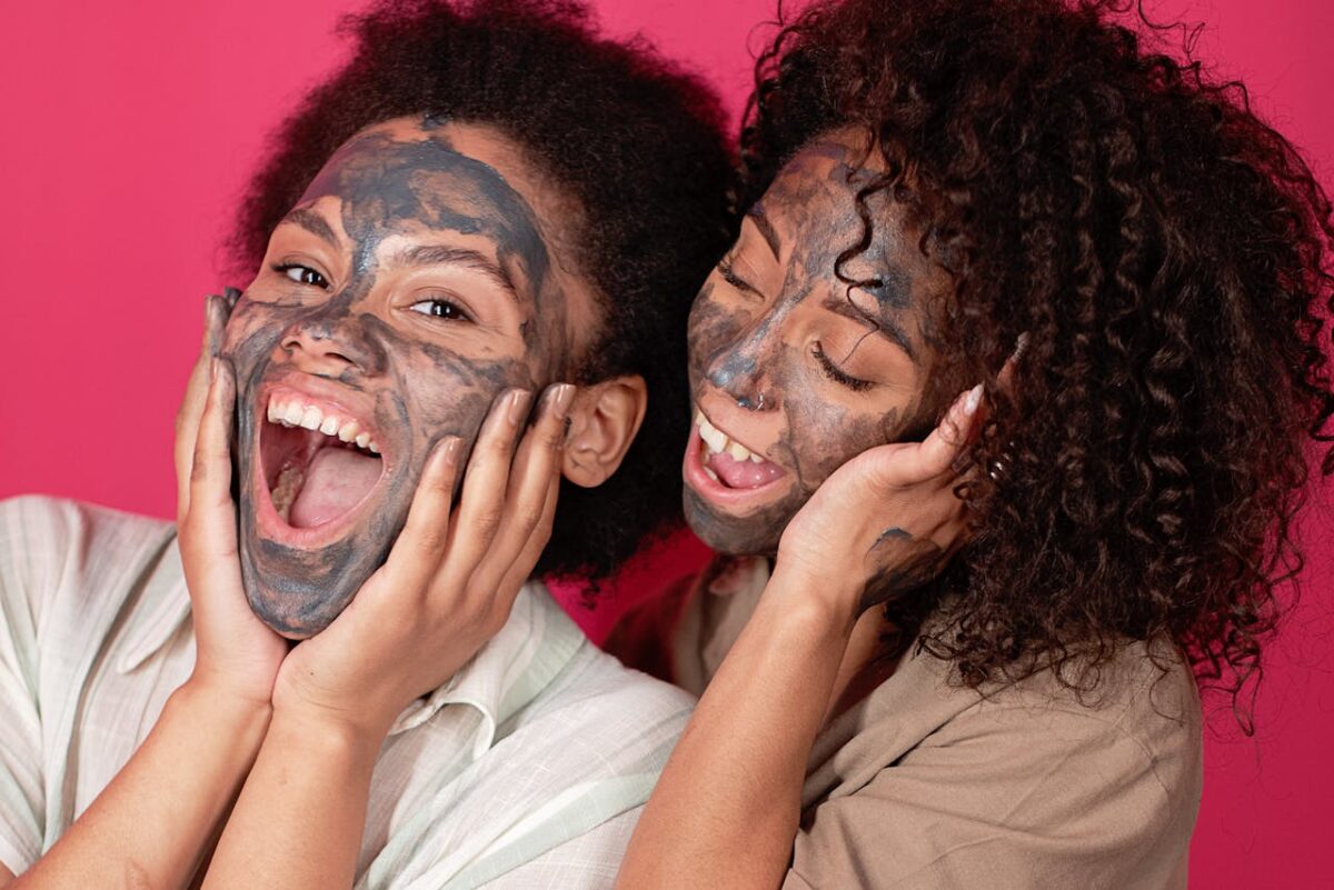 Two women enjoying a fun skincare session with face masks, exuding joy and relaxation.